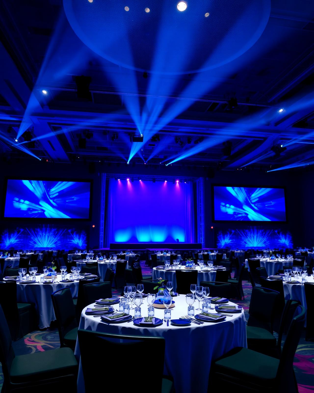 Salón de eventos corporativos iluminado en azul